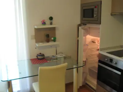 a small kitchen with a glass table and a refrigerator at Апартаменты Aphrodite Roce in Sunny Beach
