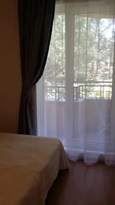 a bedroom with a bed and a window with a balcony at Апартаменты Aphrodite Roce in Sunny Beach