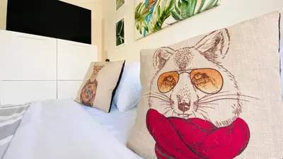 a bed with a pillow with a fox wearing glasses at APARTELLO ARTUR - Modern Studios - Sveti Vlas in Sveti Vlas