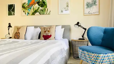 a bedroom with a bed and a blue chair at APARTELLO ARTUR - Modern Studios - Sveti Vlas in Sveti Vlas