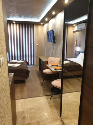 a hotel room with a bed and a desk and a mirror at MitProt luks studio Panorama Bay 2 ap39 in Sveti Vlas