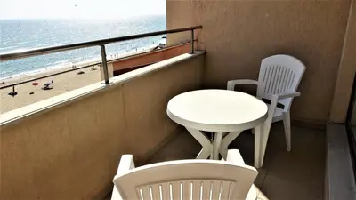 a balcony with a table and chairs and the beach at Seafront Apartment im Obzor Beach Resort in Obzor