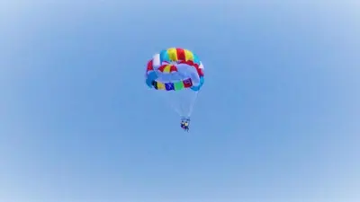 a person flying a parachute in the sky at Seafront Apartment im Obzor Beach Resort in Obzor