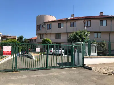 a green gate in front of a building at Briz MK Apartment in Ravda