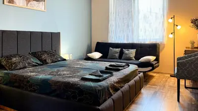 a bedroom with a large bed and a couch at Briz MK Apartment in Ravda