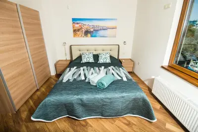 a bedroom with a large bed with blue pillows at Breeze Guest House in Chernomorets