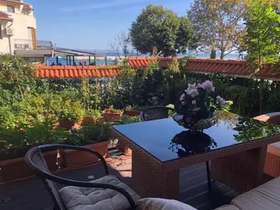 a table with a vase of flowers on it at Breeze Guest House in Chernomorets