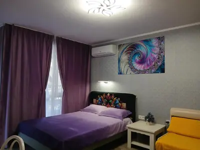 a bedroom with a bed and a painting on the wall at PARUS-2-STUDIO in Pomorie