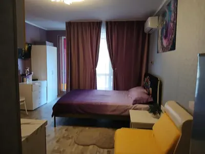 a bedroom with a bed and a couch and a window at PARUS-2-STUDIO in Pomorie