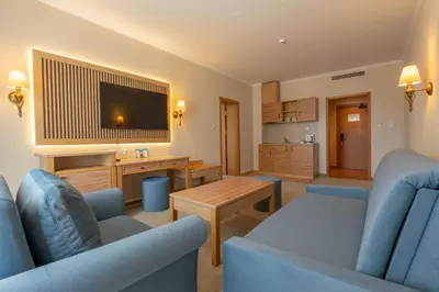 a living room with two blue chairs and a television at DIT Majestic Beach Resort in Sunny Beach
