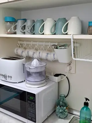 a kitchen with a microwave and cups and dishes at Stensi Atlantis studia in Ravda