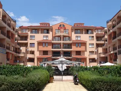 a large pink building with bushes in front of it at Apart Hotel Efir in Sunny Beach