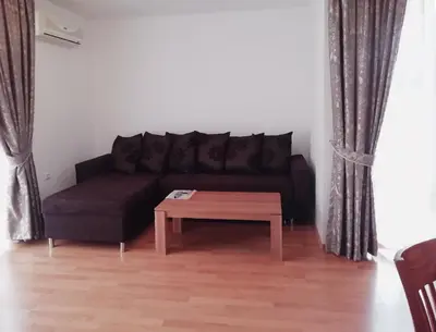 a living room with a black couch and a coffee table at Apart Hotel Efir in Sunny Beach