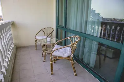 a balcony with two chairs and a table and a window at Private Studio in Planet Hotel, Sunny Beach Center by Flаt Manаger in Sunny Beach