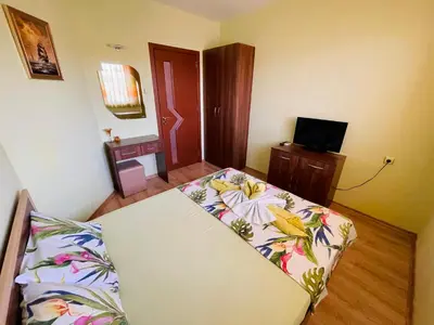 a living room with a couch and a television at Kastela Guest House in Chernomorets