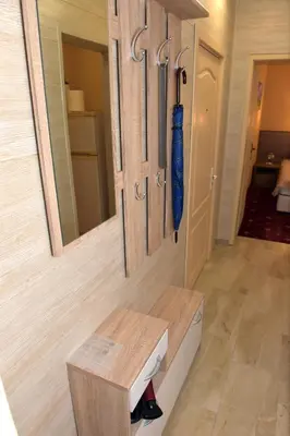a hallway with a wooden bench and a mirror at City apartments in Varna City