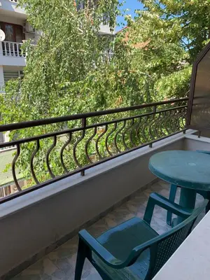 a green table and a chair on a balcony at Guest rooms Sveti Nikola in Pomorie