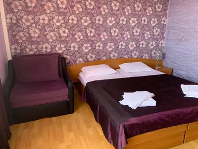 a bedroom with a bed and a chair at Guest rooms Sveti Nikola in Pomorie