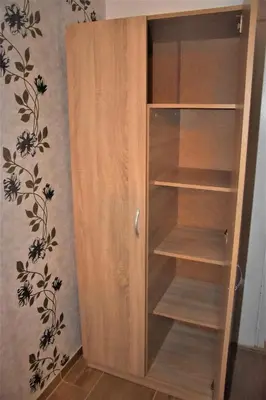 a wooden book shelf in a room with a wall at Bungalows Dani in Kamchia