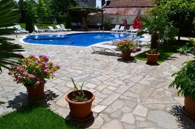 a patio with potted plants and a swimming pool at Saint George Family Hotel in Lozenets