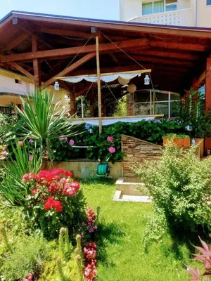 a garden with flowers in front of a building at Saint George Family Hotel in Lozenets