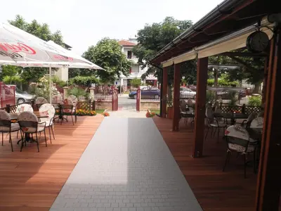 a walkway with tables and chairs on a sidewalk at Saint George Family Hotel in Lozenets