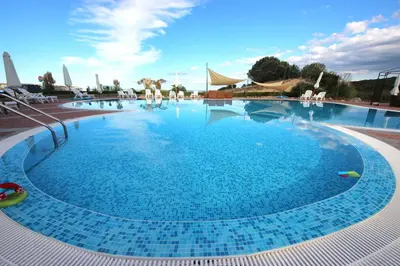 a large swimming pool with blue water in a resort at Menada Sozopol Apartments in Sozopol