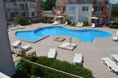 a swimming pool with lounge chairs at Мезонет Сиракови in Sozopol