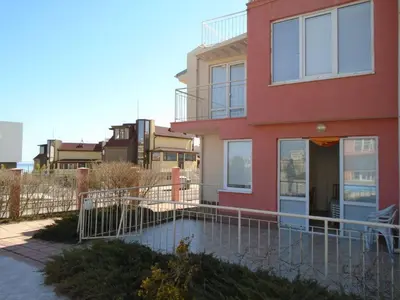 a red house with a pool in front of it at Мезонет Сиракови in Sozopol