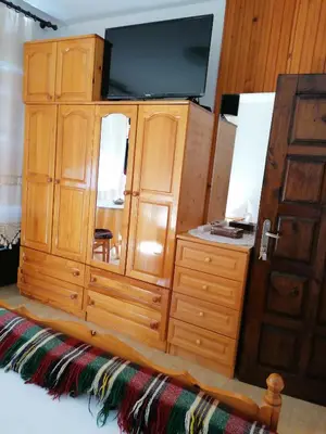 a large wooden cabinet with a television on top at Апартамент КИМАКО 2, 100м2 на цена за хотелска стая за двама in Tsarevo