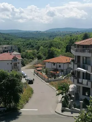 a street in a small town with buildings and cars at Апартамент КИМАКО 2, 100м2 на цена за хотелска стая за двама in Tsarevo