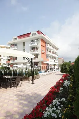 a large apartment building with a patio and flowers at Hotel Zaara in Sunny Beach