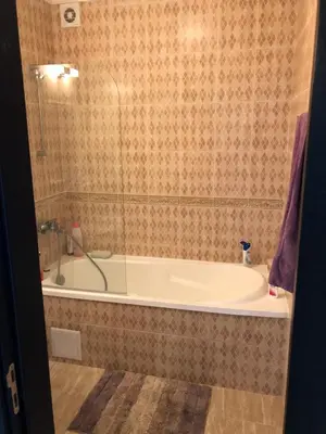 a bath tub in a bathroom with a shower at Amazing apartment facing the sea in Burgas City