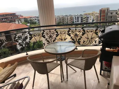 a balcony with a table and chairs and the ocean at Amazing apartment facing the sea in Burgas City