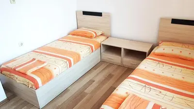 a bedroom with two beds and a desk at Kirovi House - guest rooms in Tsarevo