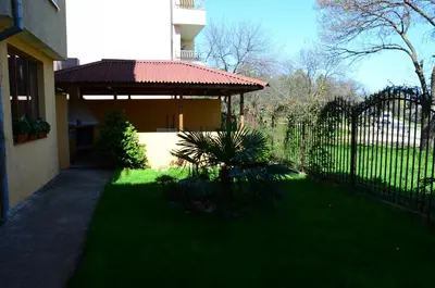 a fence in front of a house with a gazebo at Kirovi House - guest rooms in Tsarevo