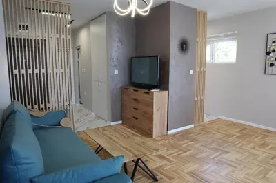 a living room with a blue couch and a tv at Studios near to Burgas Free University in Burgas City