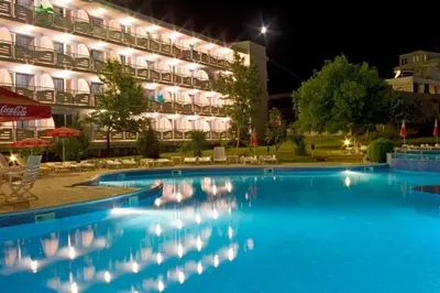 a swimming pool in front of a hotel at night at Belitsa Hotel in Primorsko