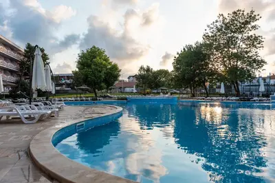a large swimming pool with chairs and umbrellas at Belitsa Hotel in Primorsko