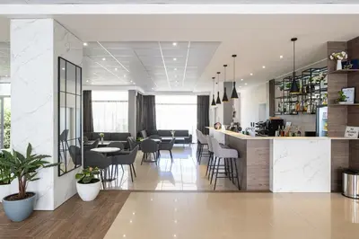 a dining room with a bar and tables and chairs at Belitsa Hotel in Primorsko
