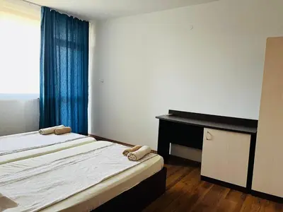a bedroom with two beds and a desk and a window at Paunovi Guest House in Primorsko