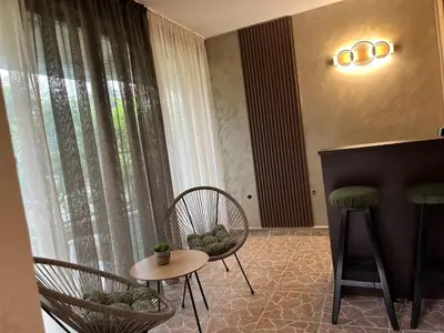 a room with two chairs and a table and a piano at Paunovi Guest House in Primorsko
