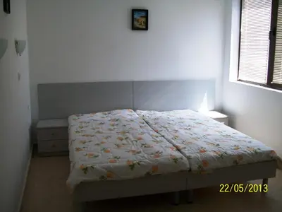 a bedroom with a bed with a comforter on it at Apartment in Kambani 1 Apartcomplex in Sveti Vlas