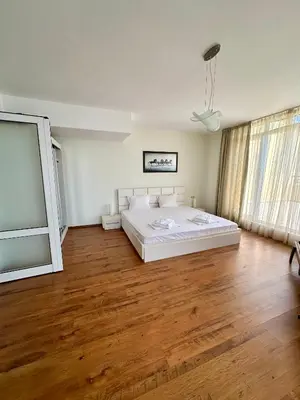 a bedroom with a large white bed and wooden floors at PSB Apartments in Midia Resort Aheloy in Aheloy
