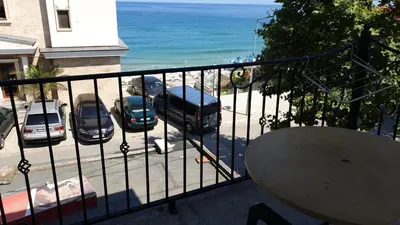 a balcony with a view of a parking lot and the ocean at Майстор Костадин - 1878 in Obzor