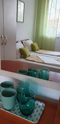 a room with two beds with green bowls on a shelf at Майстор Костадин - 1878 in Obzor