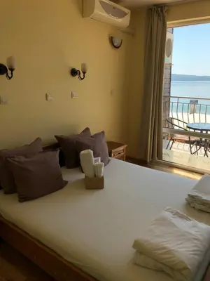 a bedroom with a large bed with a view of the ocean at Family Hotel Littoral in Sozopol