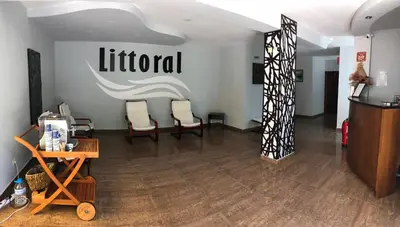 a living room with two chairs and a sign on the wall at Family Hotel Littoral in Sozopol
