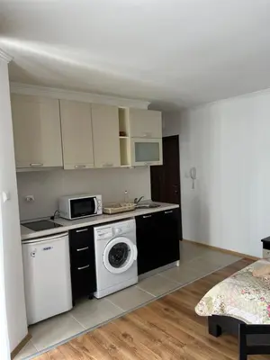 a kitchen with a washing machine and a microwave at Antorini Apartments in Sveti Vlas