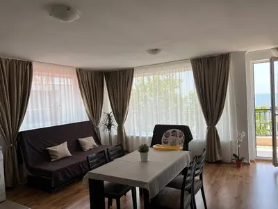 a living room with a table and a couch at Antorini Apartments in Sveti Vlas